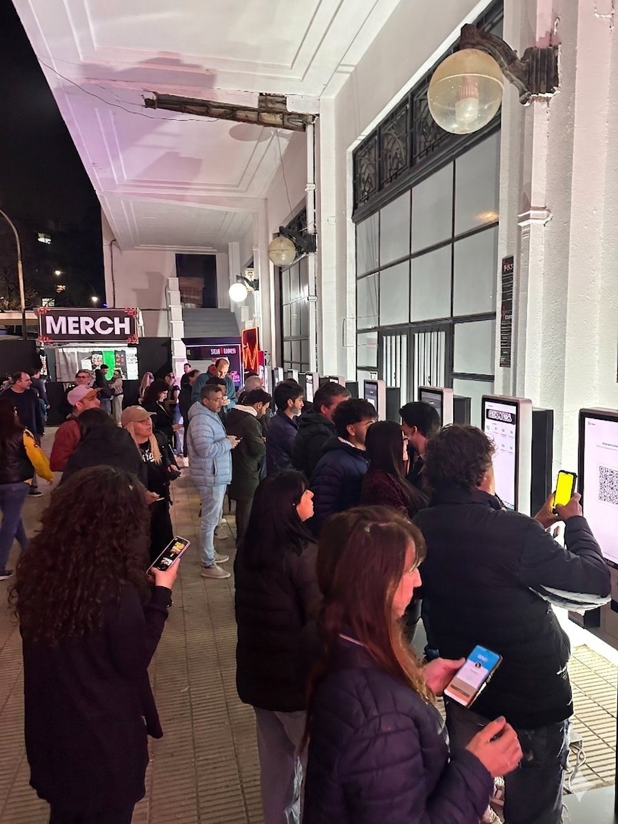 Fila de personas usando tótems de autoservicio OrderFast en un evento masivo